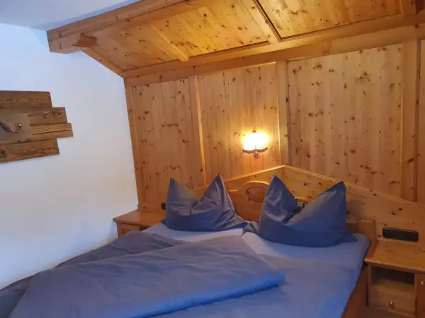 Großzügiges Schlafzimmer unter der Dachschräge, komplett in Holz gestaltet.
