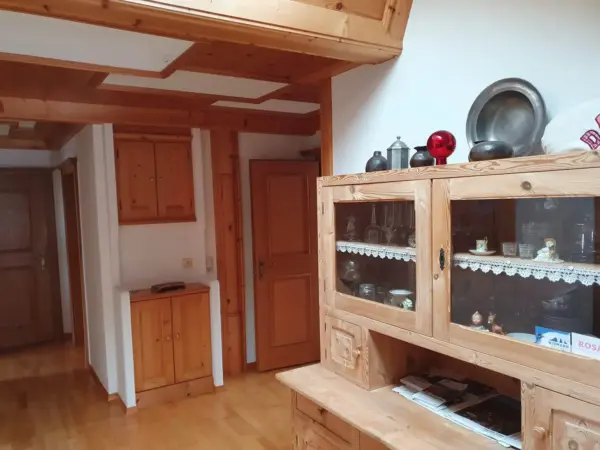 Einladender Flur der Ferienwohnung mit rustikalem Bauernschrank und viel Holz.